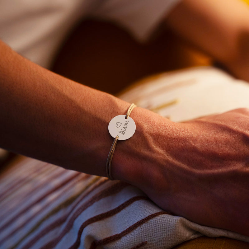 Optez pour l'originalité avec ce bracelet médaille 20mm personnalisé, cordon beige, et deux trous en argent.
