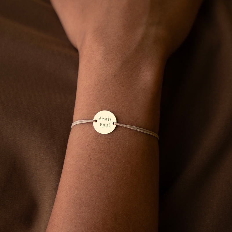 bracelet personnalisé, arborant une médaille plaquée or de 15mm, deux trous pratiques, et un cordon beige.