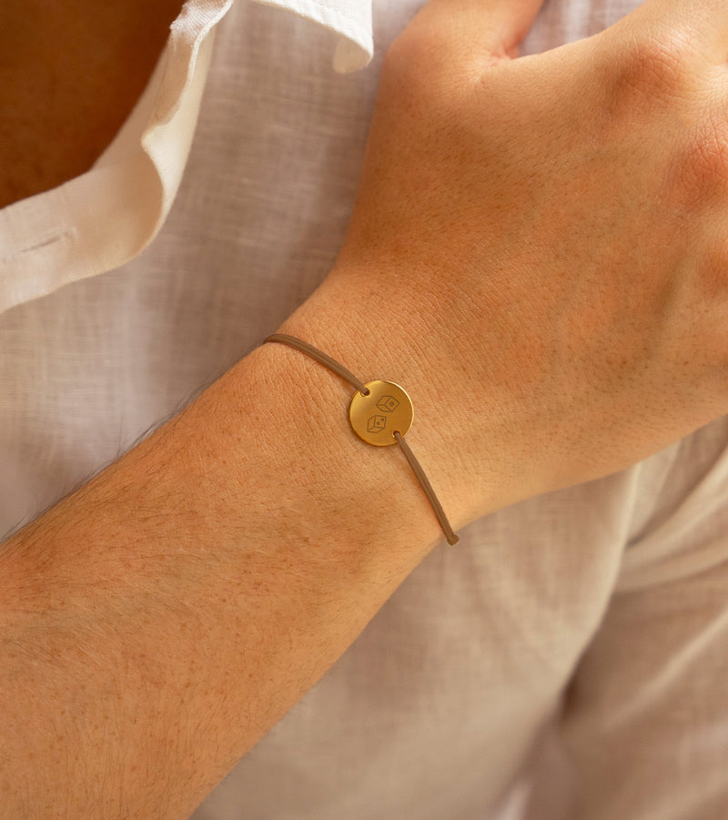 bracelet personnalisé, avec une médaille plaquée or de 15mm et deux trous, agrémenté d'un cordon marron clair.