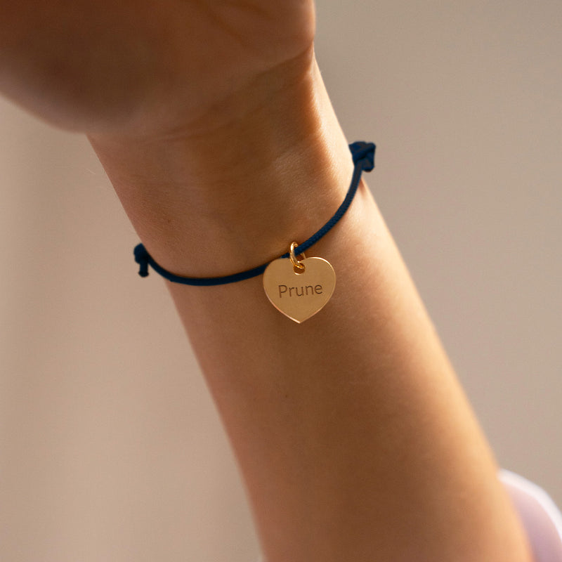 Un bracelet avec un cordon en bleu marine et un cœur en plaqué or 15mm.