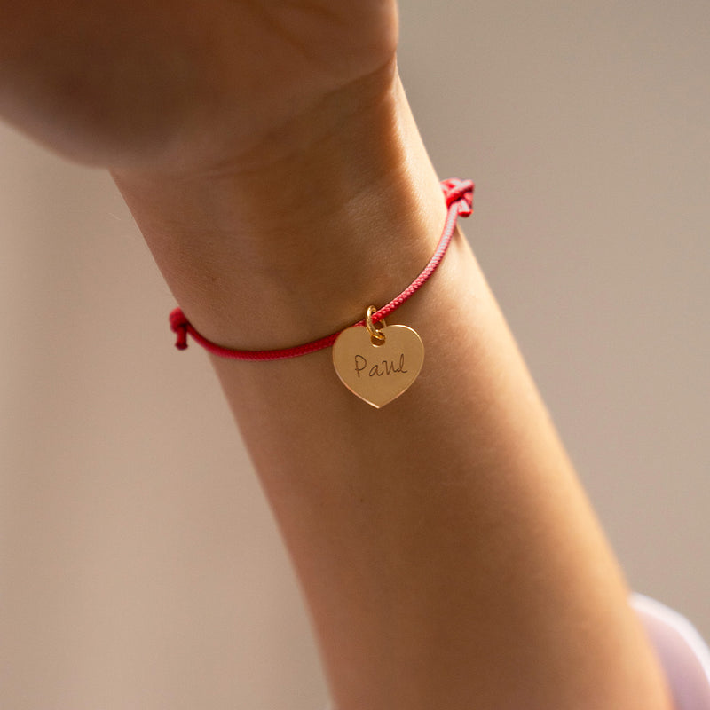 Bracelet personnalisé en cordon rouge met en valeur un délicat cœur plaqué or de 15mm.