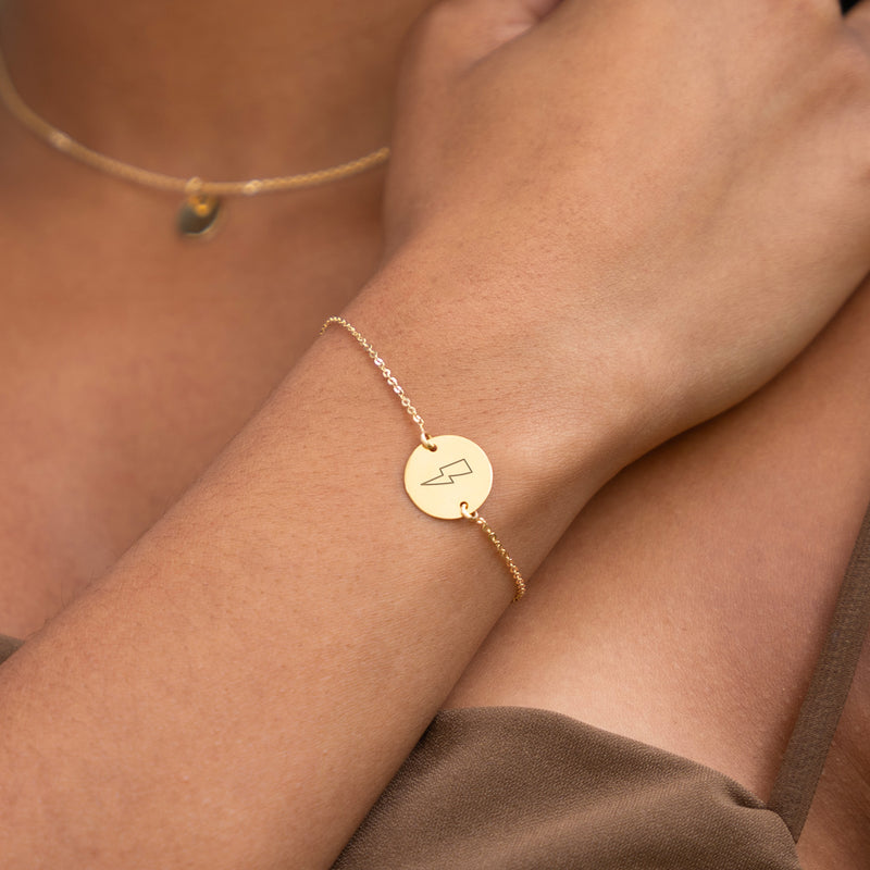 Bracelet en plaqué or, agrémenté d'une médaille personnalisée de 15mm, offre une touche de raffinement avec sa chaîne plate et ses deux trous distinctifs.