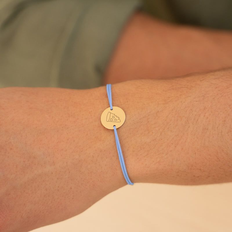 Ce bracelet, orné d'une médaille de 15mm et de deux trous, est plaqué or avec un cordon bleu pastel.