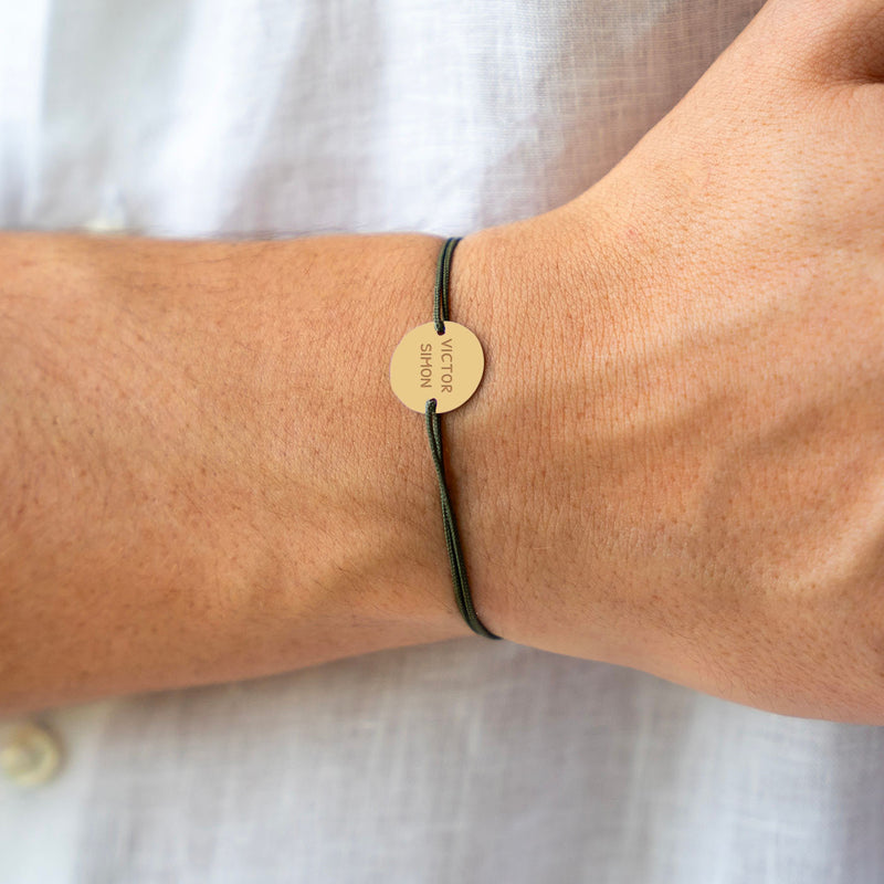 Un bracelet personnalisé en plaqué or, orné d'une médaille de 15mm à deux trous, captivant avec son cordon kaki