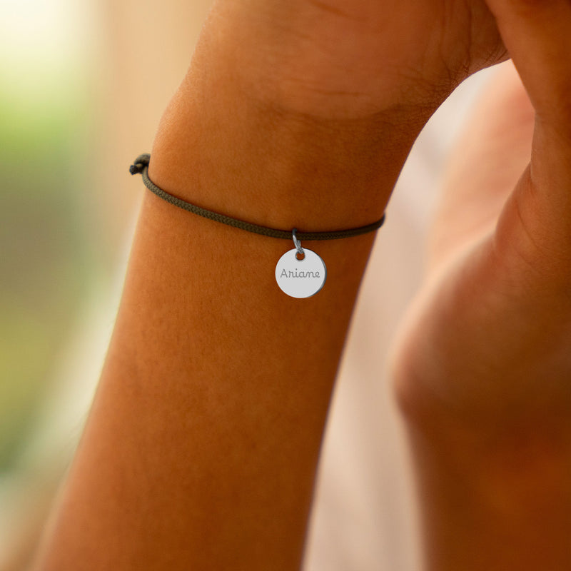 Un bracelet argenté orné d'une médaille de 10mm, parfait pour une touche sophistiquée.