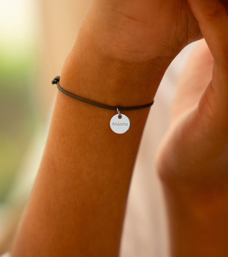 Un bracelet argenté orné d'une médaille de 10mm, parfait pour une touche sophistiquée.