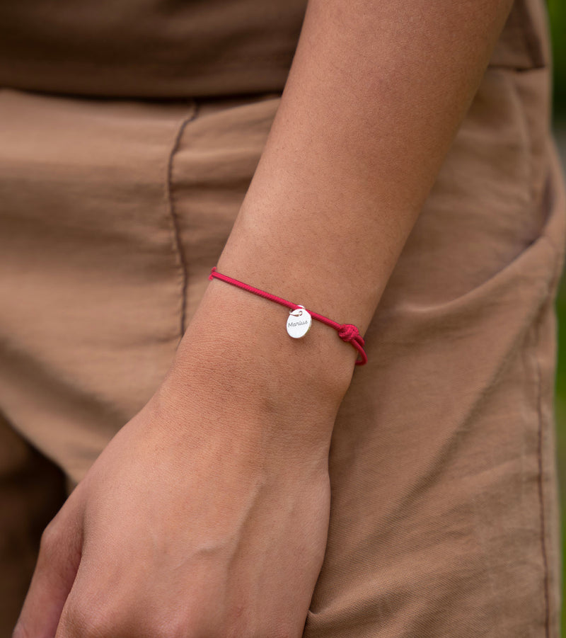 Cordon rose vif rehaussé d'une médaille argentée de 10mm, un bracelet unique à votre image.