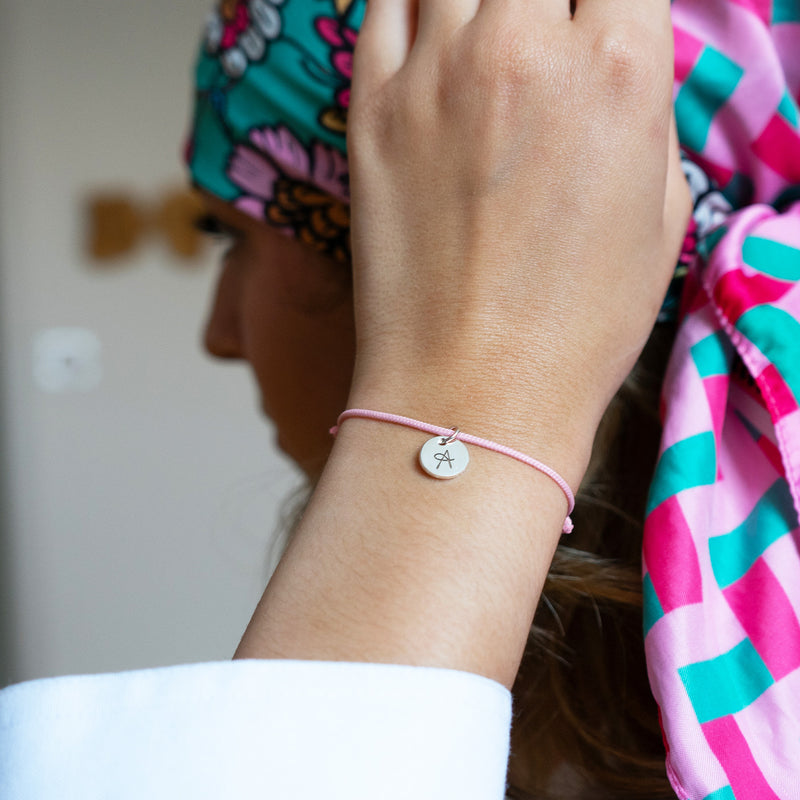 Un bracelet élégant en argent avec une médaille de 10mm et un cordon rose.
