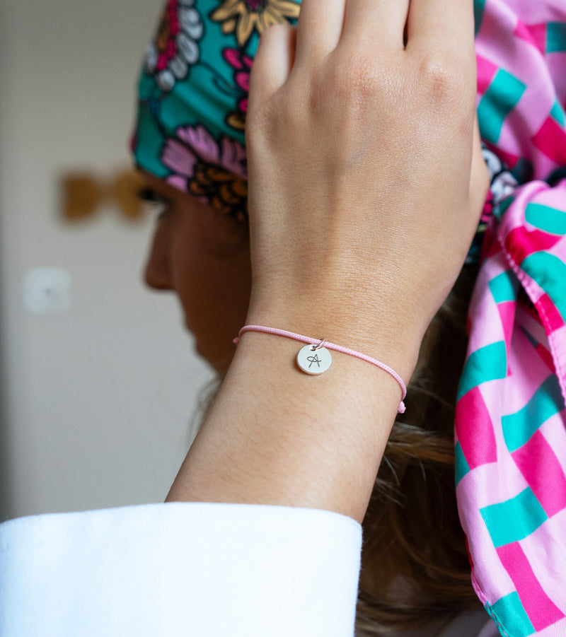 Un bracelet élégant en argent avec une médaille de 10mm et un cordon rose.