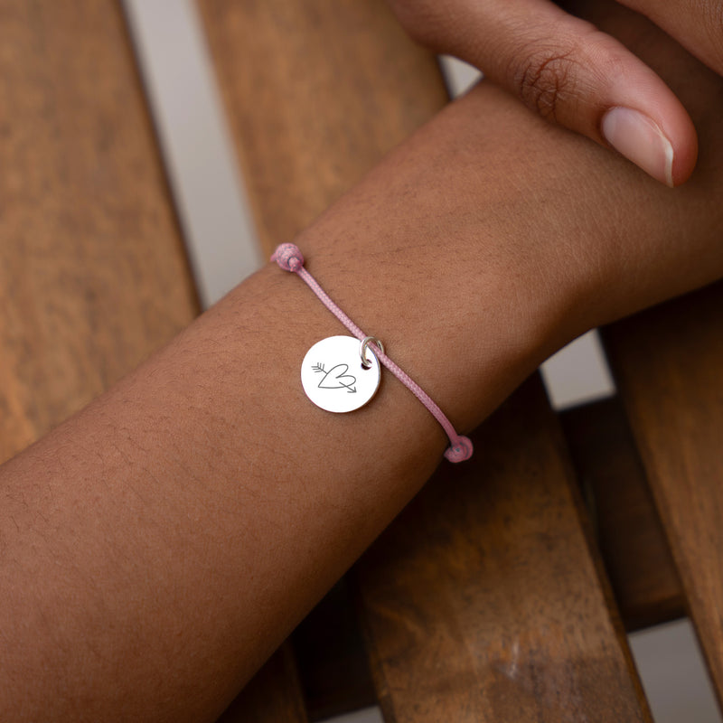 Un bracelet personnalisé en argent avec une médaille de 15mm et un cordon rose.