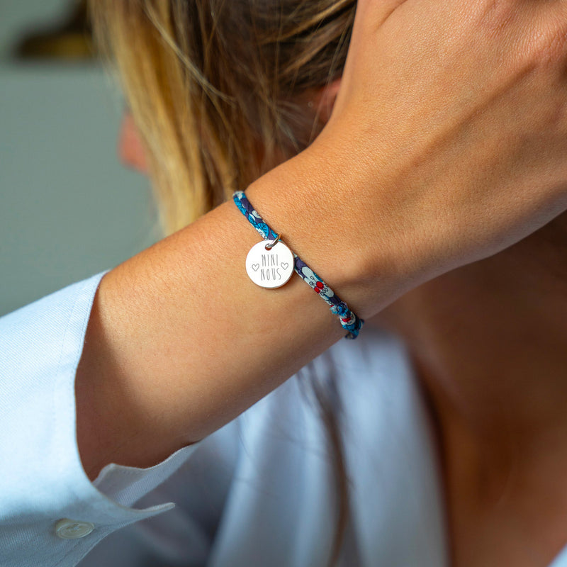 Bijou argenté composé d'une médaille de 15mm, attachée par un lien Liberty irisé.