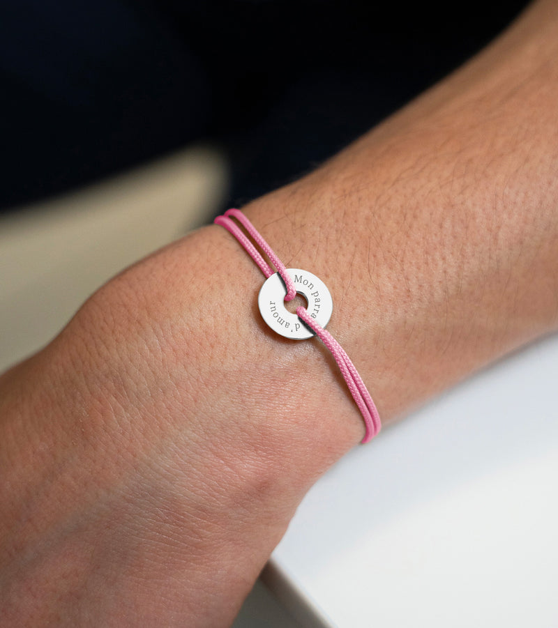 Avec un cordon rose, ce bracelet en forme de cible est personnalisé de 15mm en argent.