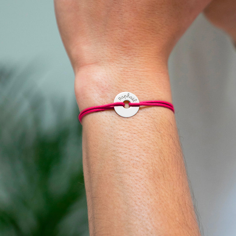 Avec un cordon rose fuchsia, ce bracelet en forme de cible est personnalisé en argent de 15mm.