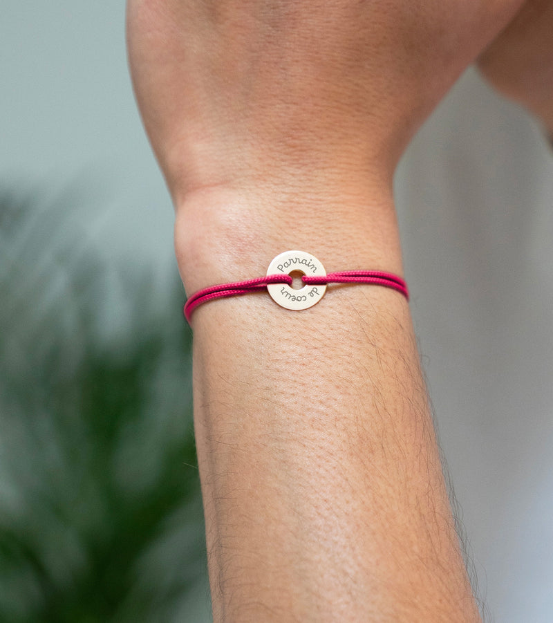 Ce bracelet plaqué or, personnalisé en 15mm, présente une forme cible avec un cordon rose fuchsia.
