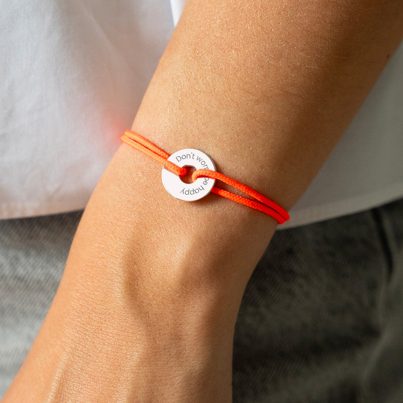 Personnalisé de 15mm en argent, ce bracelet en forme de cible est rehaussé d'un cordon orange fluo.