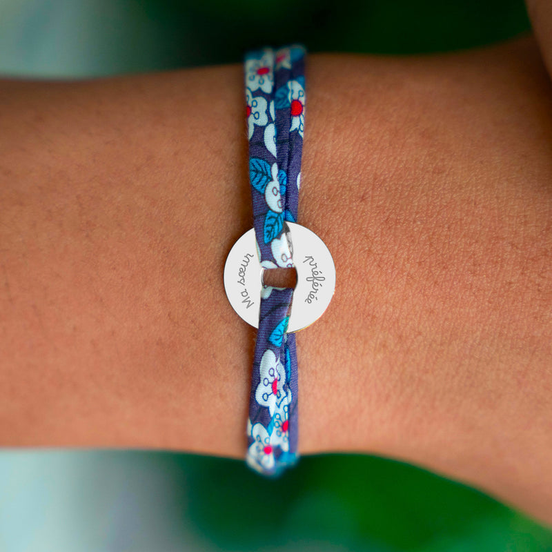 Le bracelet en cible, orné d'une médaille de 15mm en argent personnalisé, est délicatement rehaussé par un lien Liberty Iris.