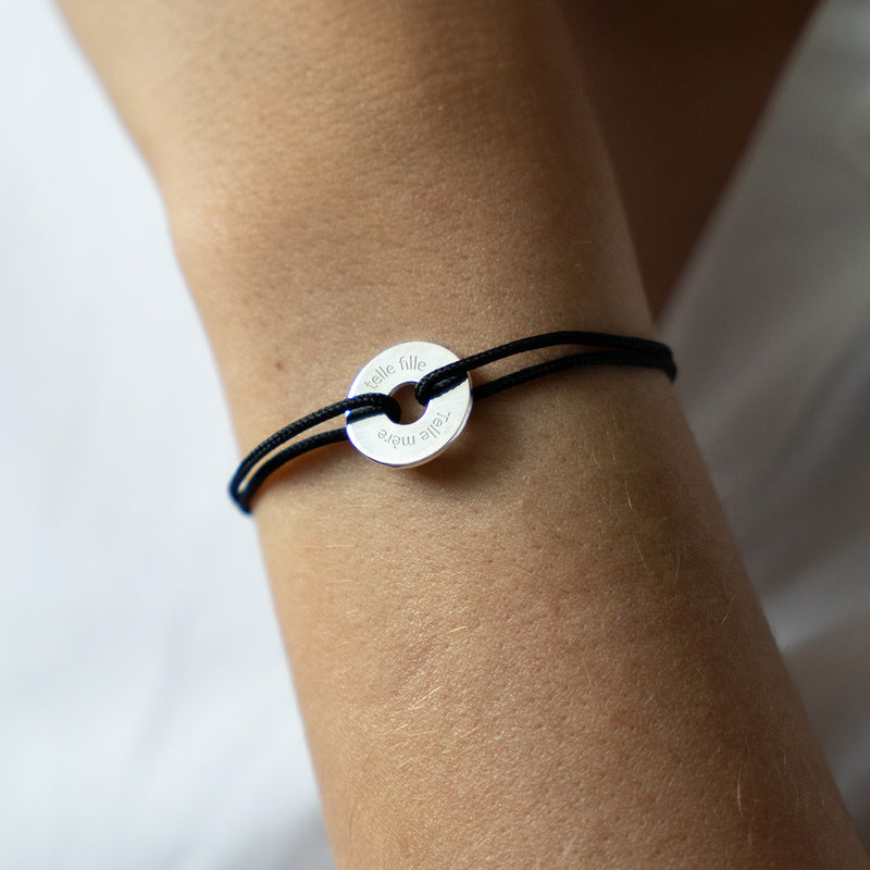 Avec son cordon noir, ce bracelet en forme de cible est personnalisé de 15mm en argent.