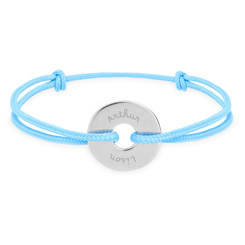 Arborant un cordon bleu pastel, ce bracelet en forme de cible est personnalisé de 15mm en argent.