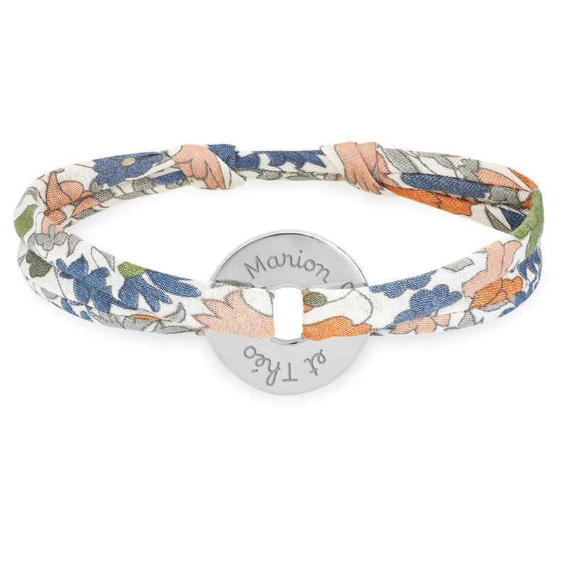 Un bracelet en forme de cible, relié par un liberty lilas, personnalisé de 15mm en argent.