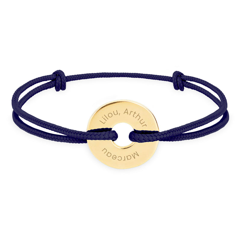 un bracelet de forme cible, personnalisé en 15mm et plaqué or, agrémenté d'un cordon bleu marine.