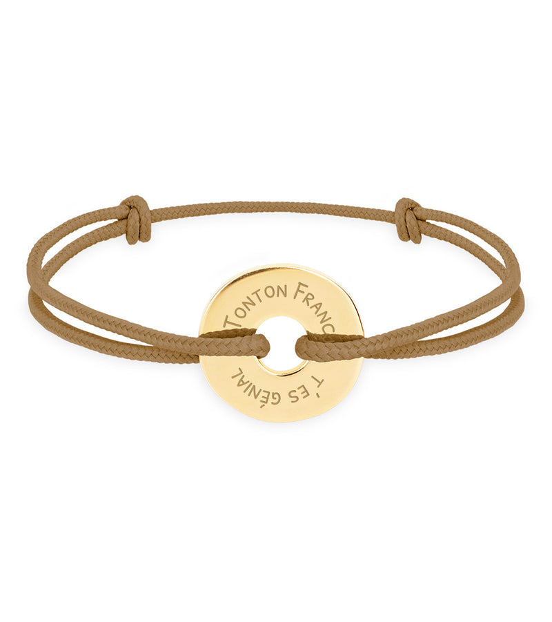 Ce bracelet plaqué or, en forme cible de 15mm, personnalisé selon vos envies, est complété par un cordon marron clair.