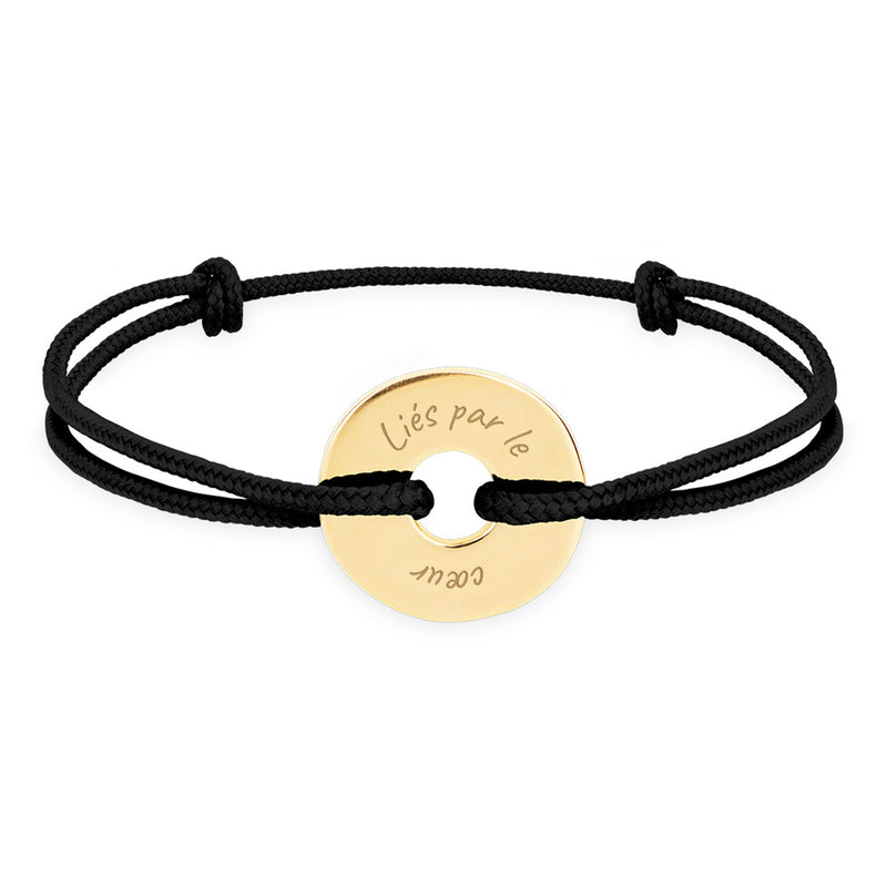 Ce bracelet plaqué or, de forme cible et personnalisé en 15mm, est assorti d'un cordon noir.
