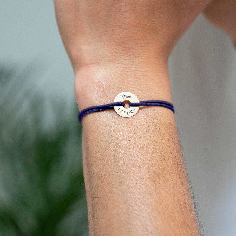 Avec une forme cible, ce bracelet personnalisé en 15mm, plaqué or, est agrémenté d'un cordon bleu marine.