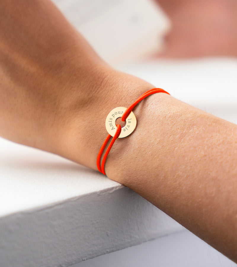 En forme de cible, ce bracelet plaqué or de 15mm personnalisé est accentué par un cordon orange fluo