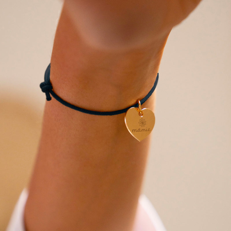 Un bracelet bleu marine agrémenté d'un cœur en plaqué or de 15mm.