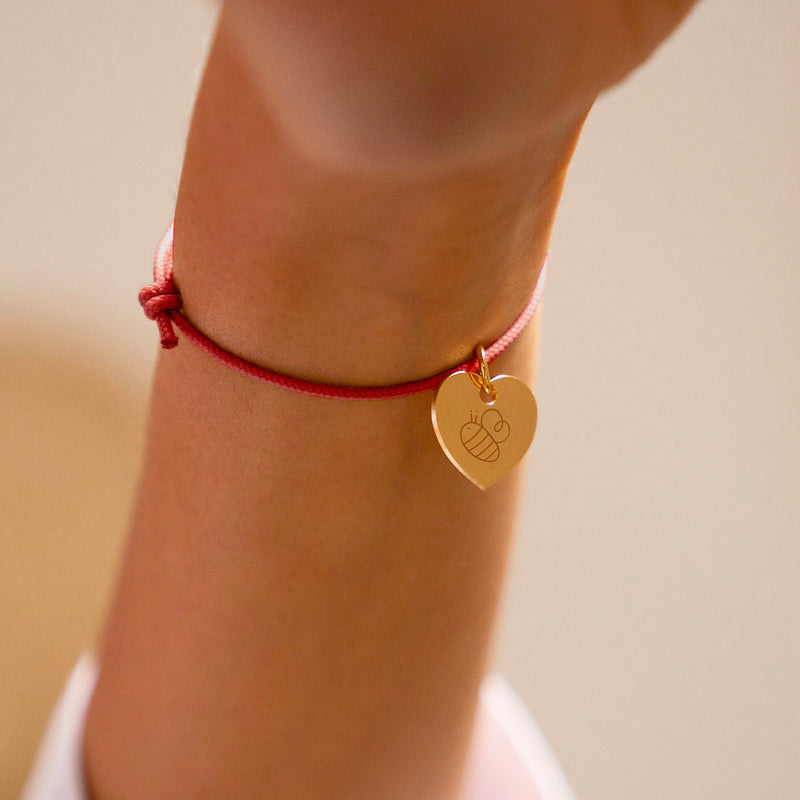 Bracelet en cordon rouge orné d'un charmant cœur plaqué or de 15mm.