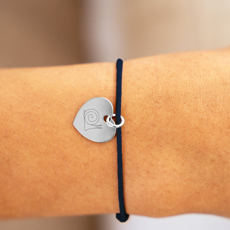 Un bracelet délicat en argent, orné d'un cœur de 15mm, sur un cordon bleu.