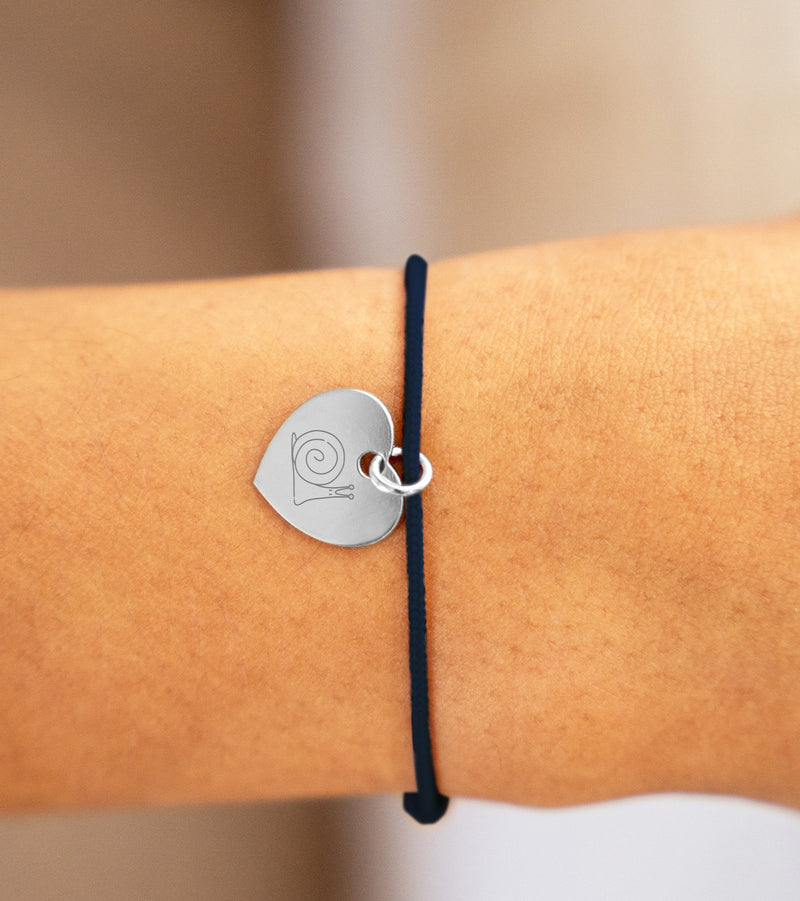 Un bracelet délicat en argent, orné d'un cœur de 15mm, sur un cordon bleu.