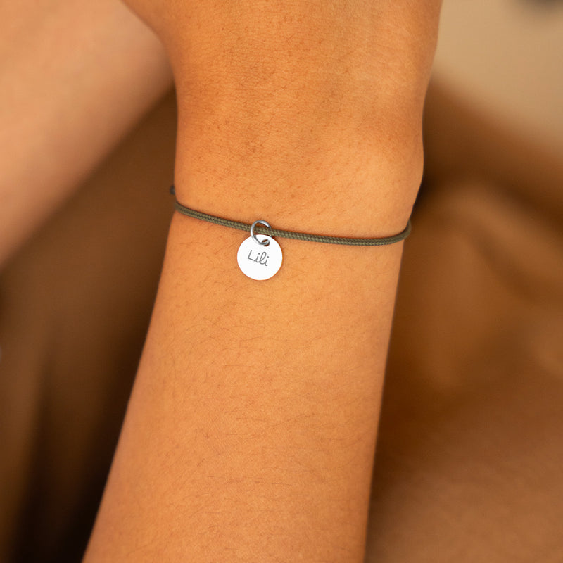Médaille de 10mm sur bracelet argenté, un accessoire chic sur cordon kaki.