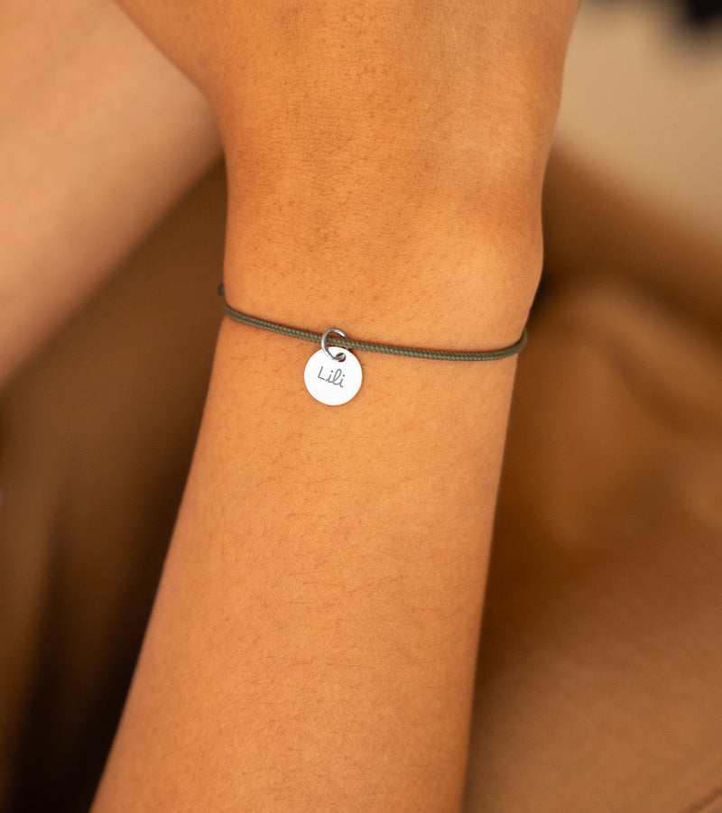 Médaille de 10mm sur bracelet argenté, un accessoire chic sur cordon kaki.