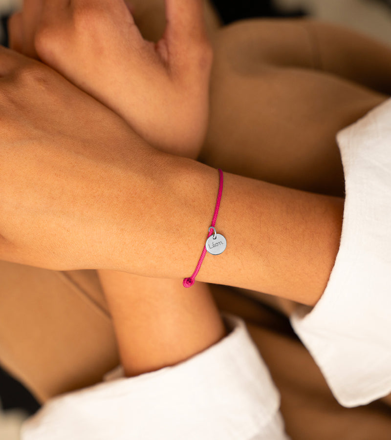 Élégant bracelet personnalisé avec une médaille argentée et un cordon rose fuchsia de 10mm.