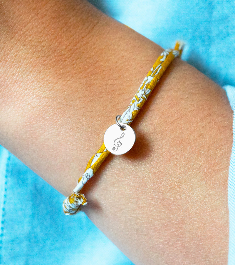 Un bracelet unique, une médaille en argent de 10mm associée à un liberty Clivia pour une touche de personnalisation.