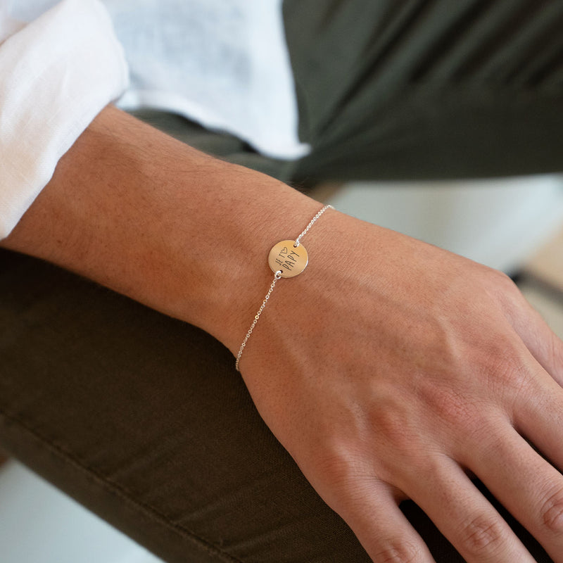 Un bracelet avec une médaille de 15mm personnalisée, présentant deux trous et une chaîne plate en argent