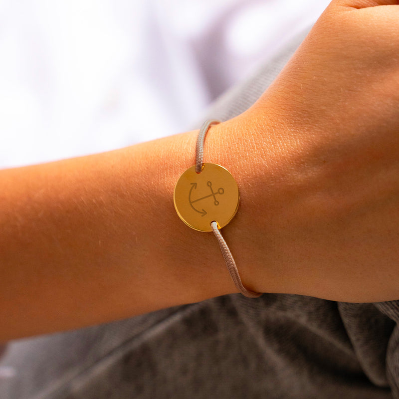 Avec une médaille personnalisée en 20mm, ce bracelet présente deux trous en plaqué or et un cordon marron clair.