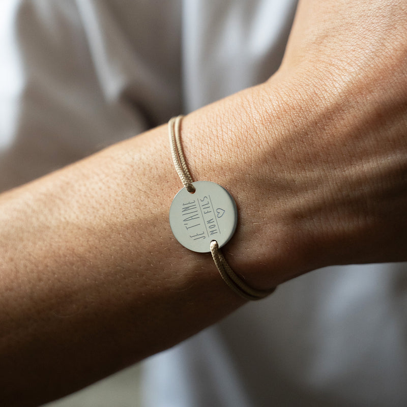 bracelet médaille en 20mm présente deux trous en plaqué argent et un cordon marron clair.