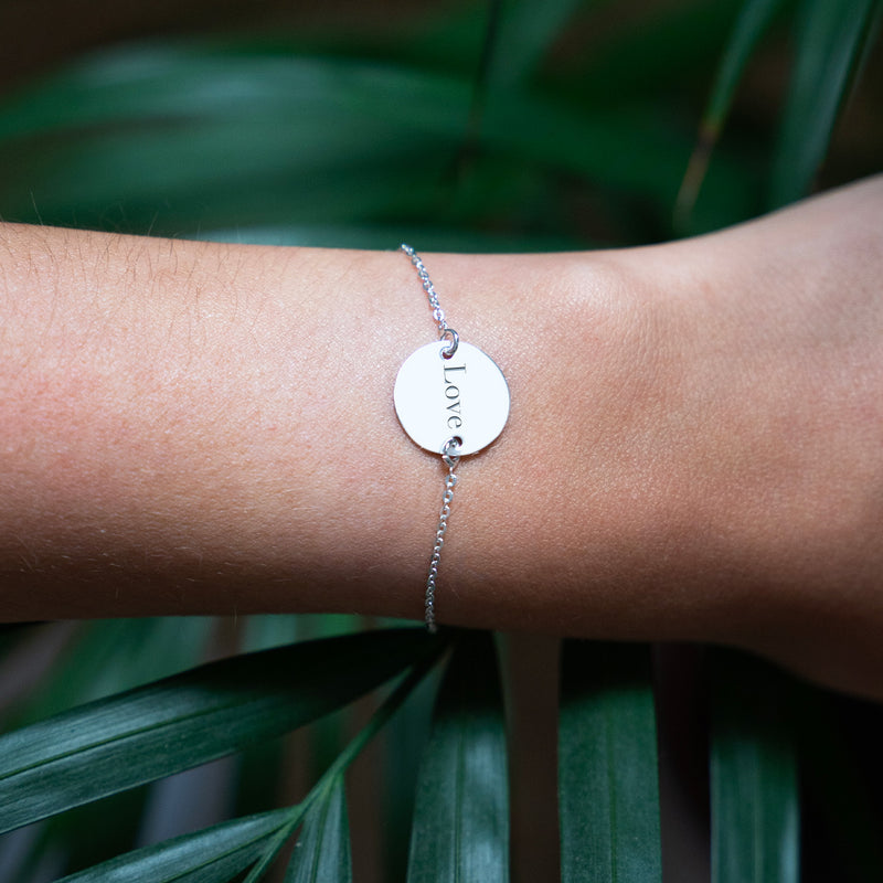 Un bracelet en argent brillant, doté d'une chaîne délicate et d'une médaille personnalisée de 15mm à deux trous.