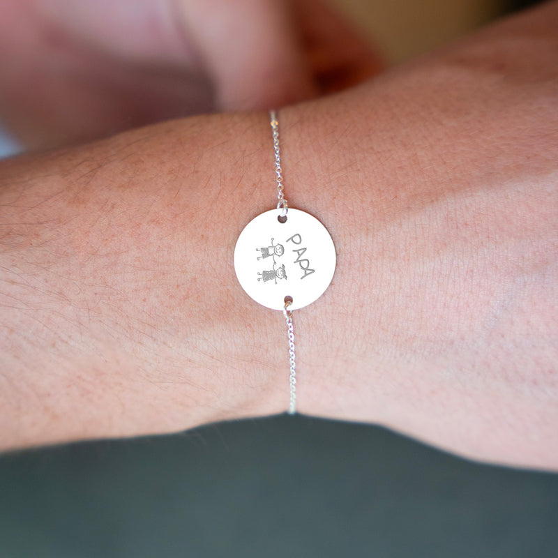 n bracelet argenté avec une médaille personnalisée de 20mm, munie de deux trous, montée sur une chaîne plate.