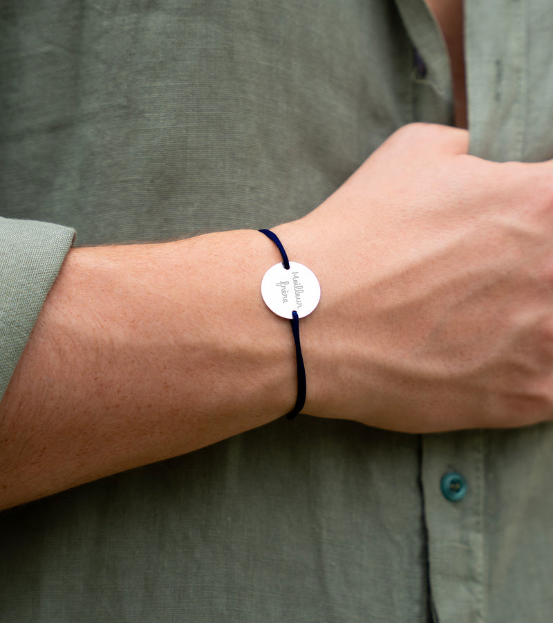 Orné d'une médaille, personnalisée en 20mm, ce bracelet comporte deux trous argent et un cordon bleu marine.