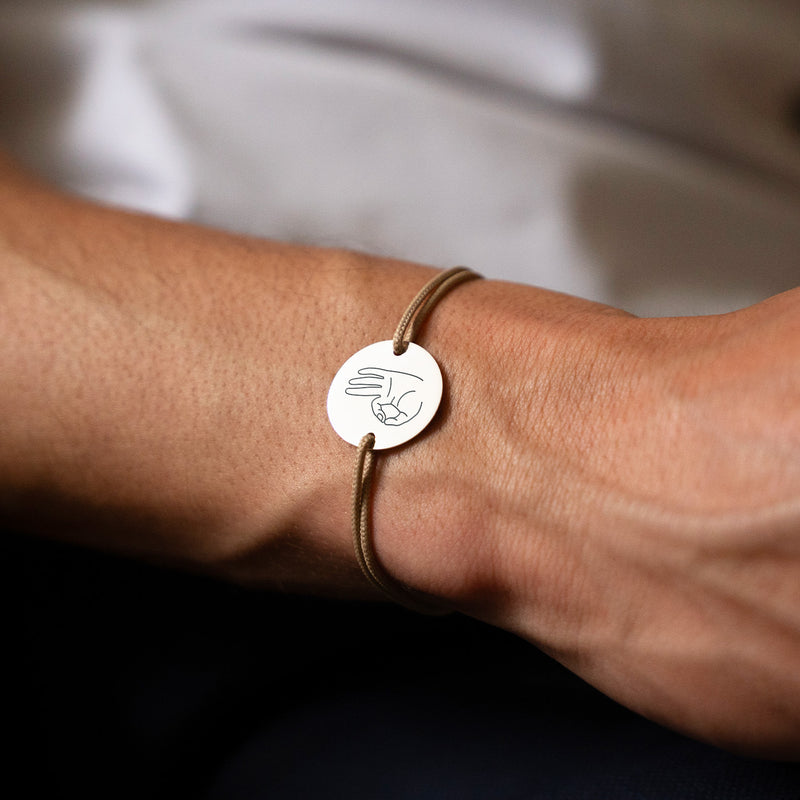 Arborant une médaille personnalisée en 20mm, ce bracelet comprend deux trous en plaqué argent et un cordon marron clair.