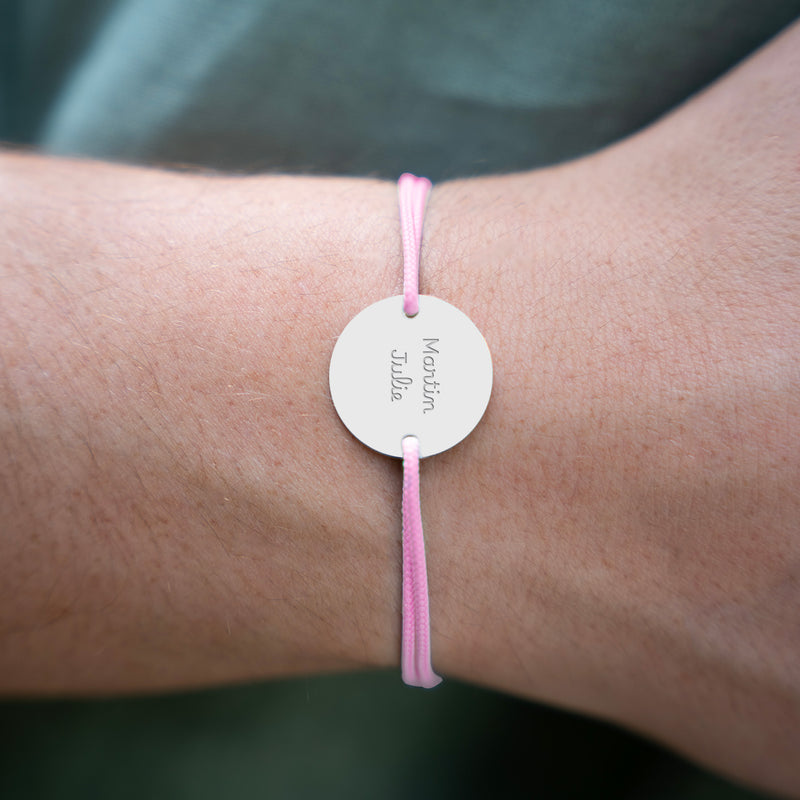 Doté d'une médaille et personnalisé en 20mm, ce bracelet intègre deux trous argent et un cordon rose.