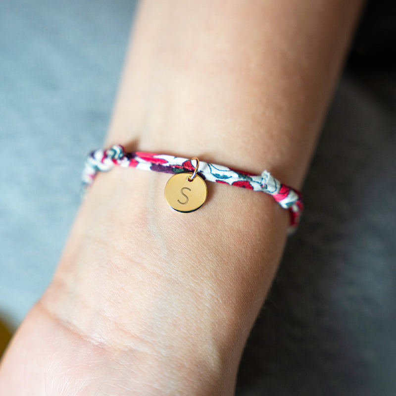 Le bracelet en Liberty Jacinthe, orné d'une médaille plaquée or de 10mm, pour une allure sophistiquée et originale.