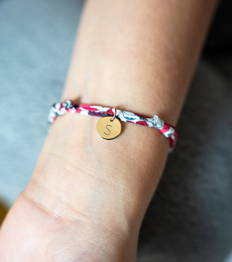 Le bracelet en Liberty Jacinthe, orné d'une médaille plaquée or de 10mm, pour une allure sophistiquée et originale.