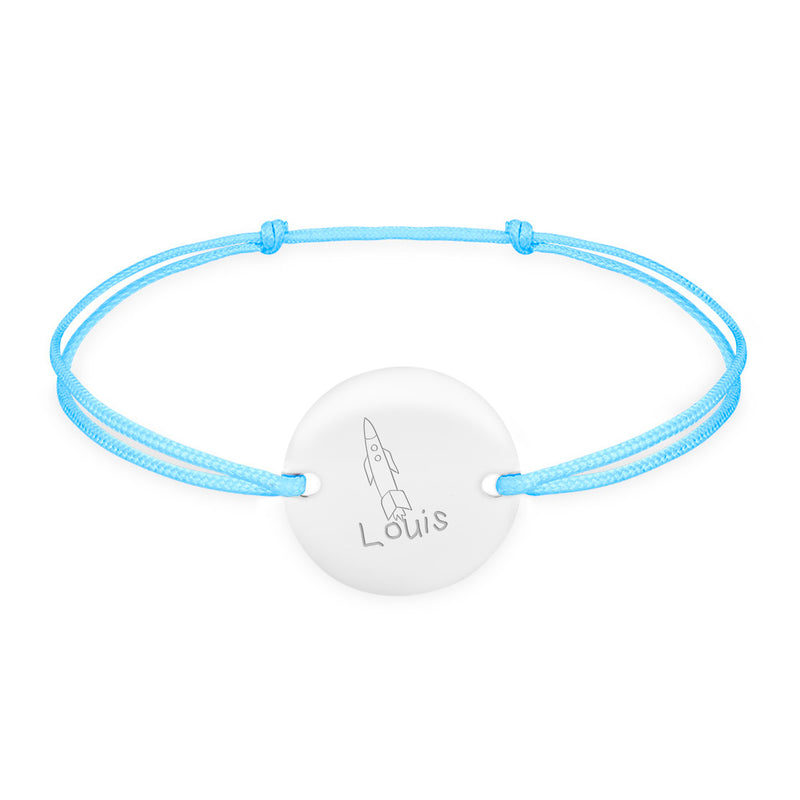 Un bracelet argenté à médaille personnalisée, orné de deux trous, se dresse fièrement sur un cordon bleu pastel.