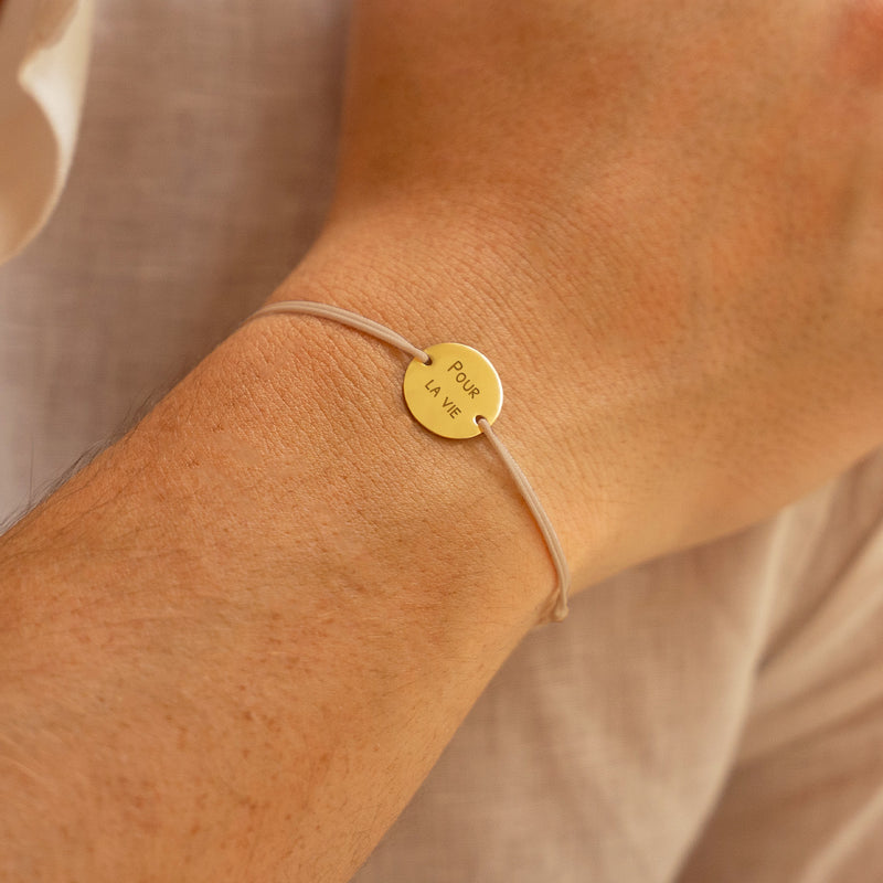 bracelet personnalisé comprenant une médaille 15mm en plaqué or, deux trous, et un cordon beige