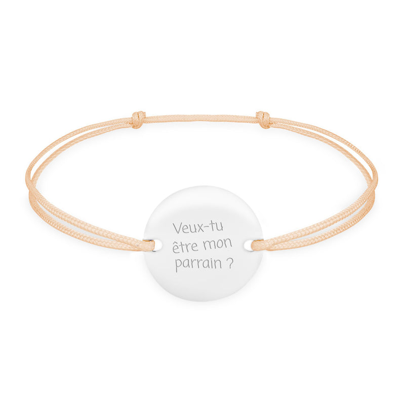 Un bracelet en argent orné d'une médaille personnalisée de 15mm, doté de deux trous pour un cordon beige.