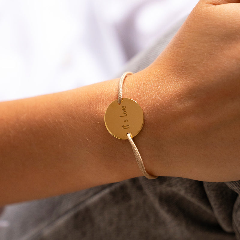 Un cordon beige avec une medaille de 20mm plaque or